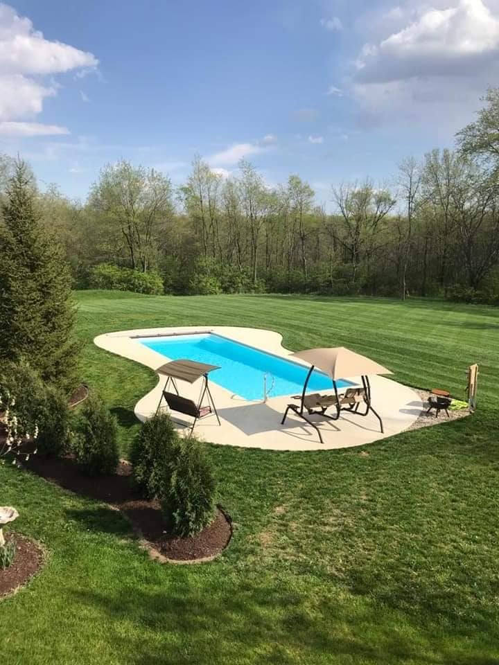 A pool that is in the middle of some grass.